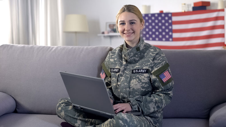 young military female on sofa using computer